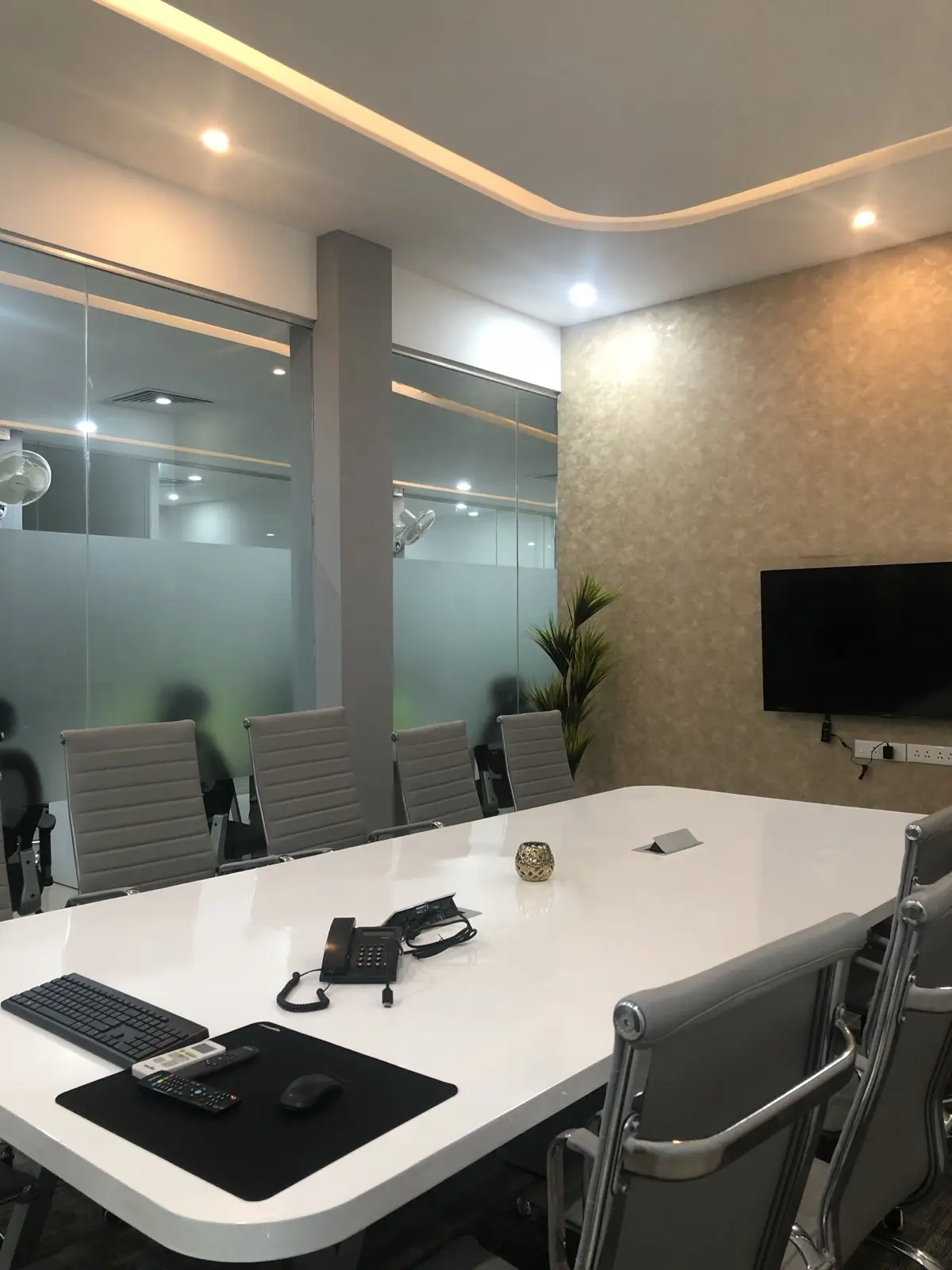 Modern conference room with glass table and presentation display