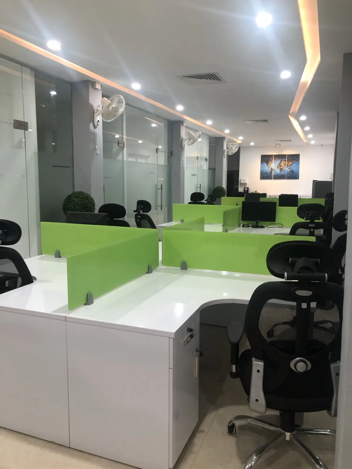 Modern open office workspace with green partitions
