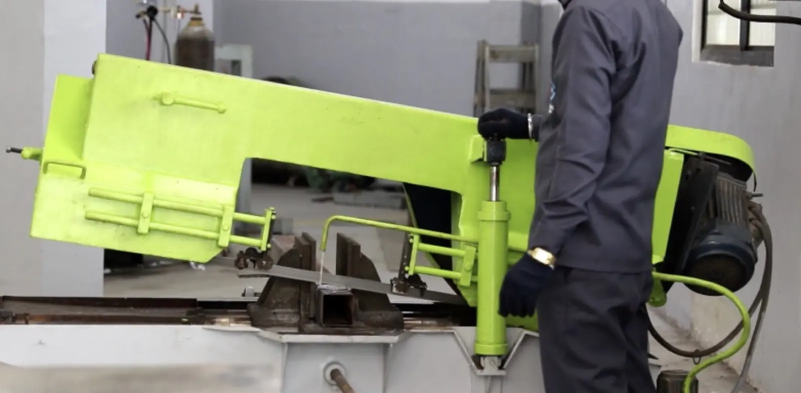 Worker operating bandsaw cutting machine